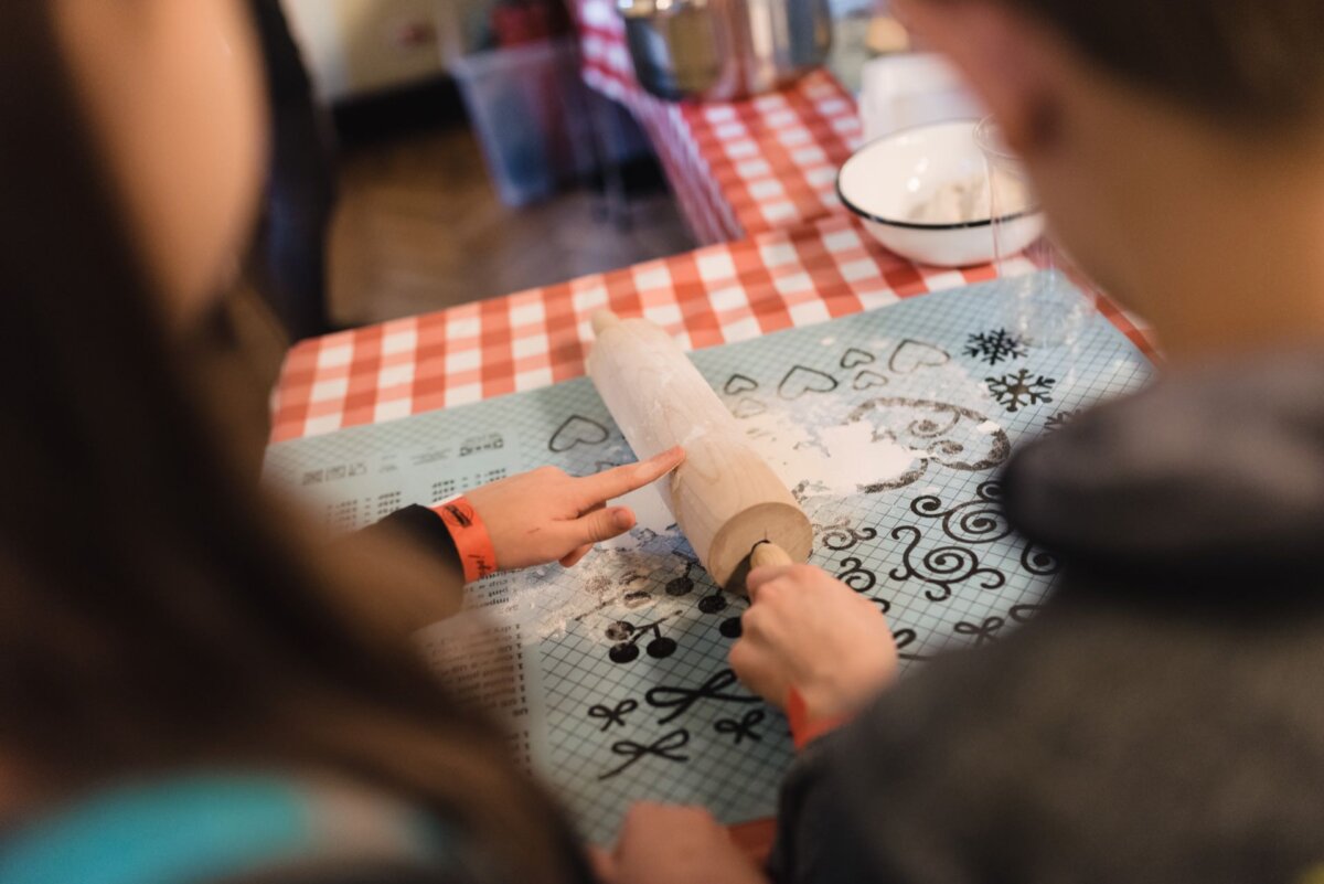 Children's hands holding and touching the dough roller