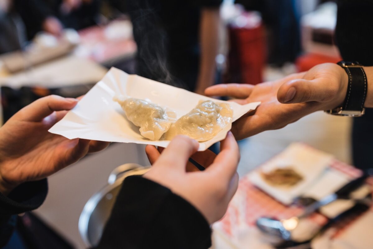 Hands passing very warm dumplings