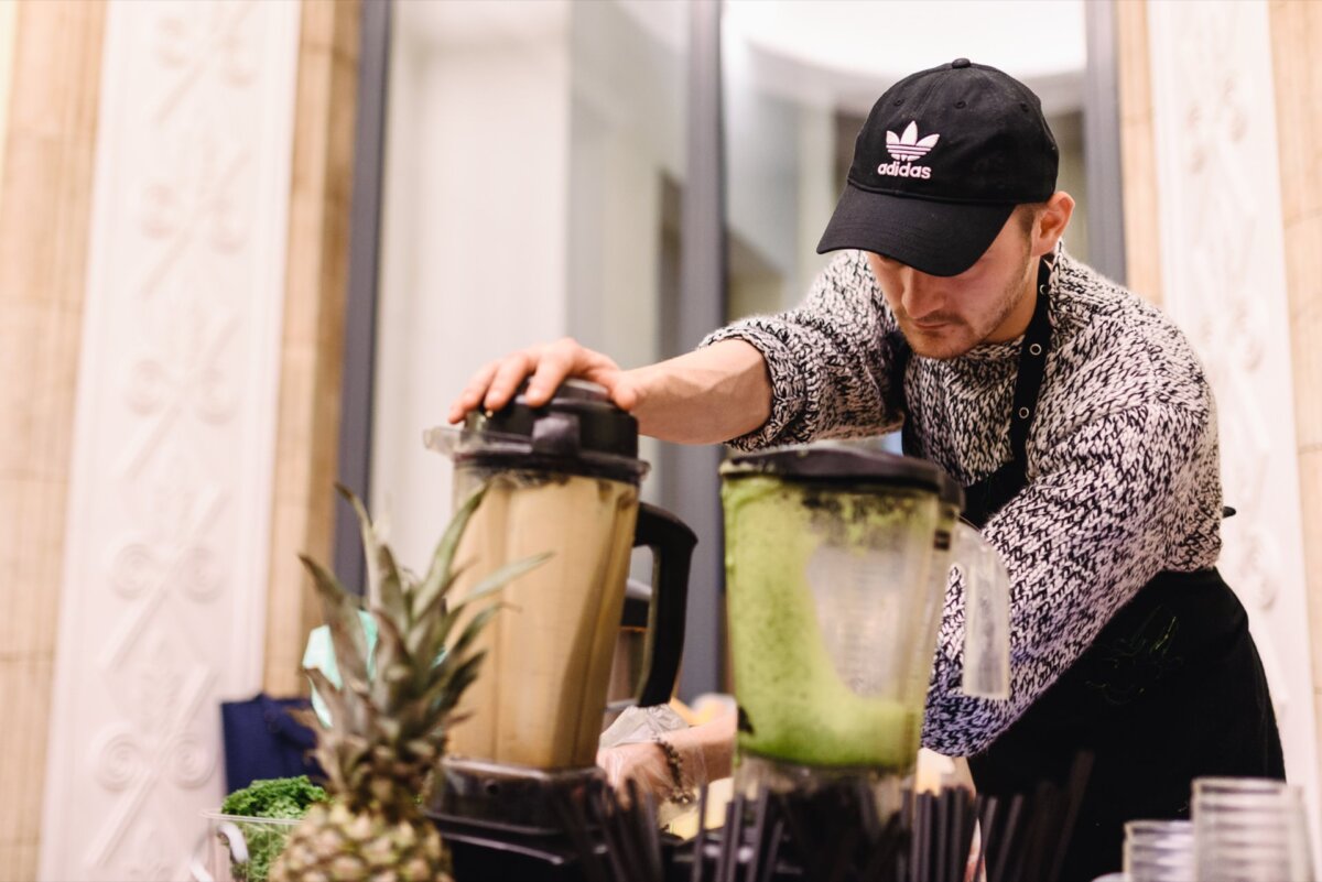 Man holding on to blender blending fruit