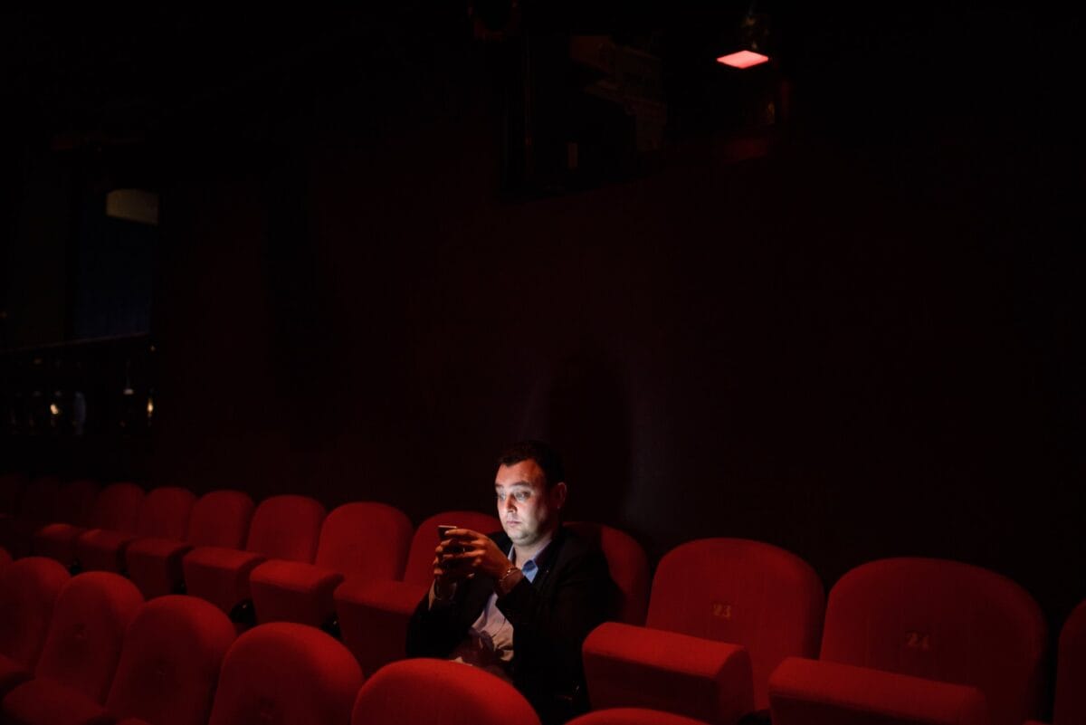 Man with phone in theater hall