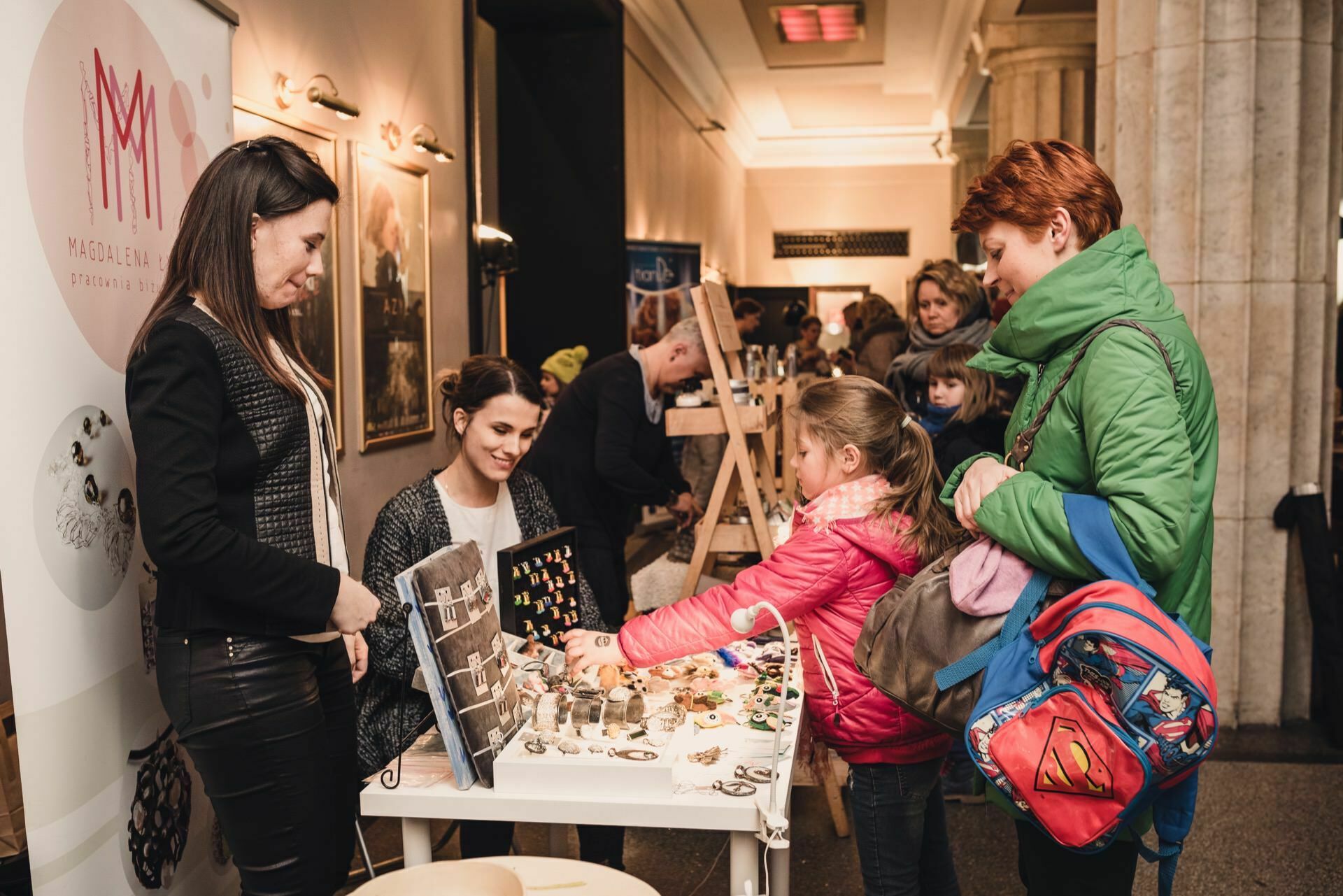 A girl looks at jewelry for a booth during a trade show at Kinoteka