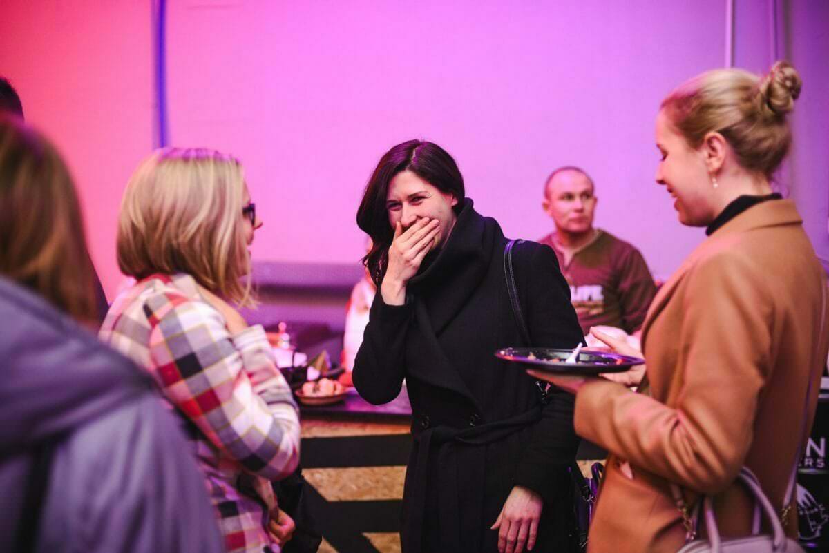 Eine lachende Frau bedeckt ihr Gesicht mit ihrer Hand