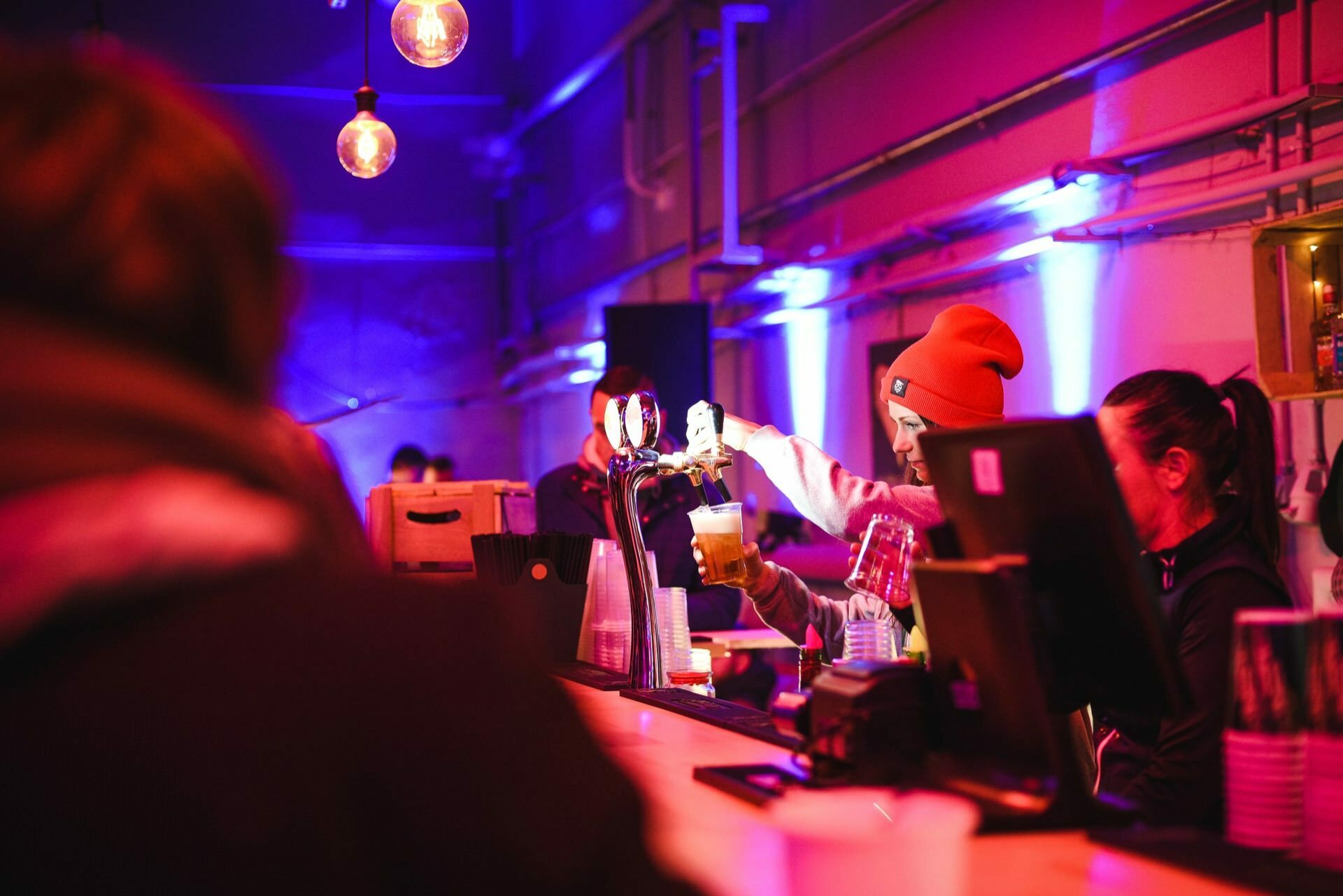 The barmaid pours beer