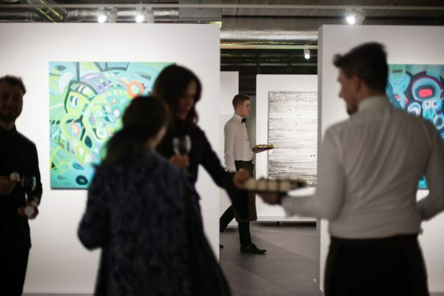 Waiters serve refreshments at art gallery