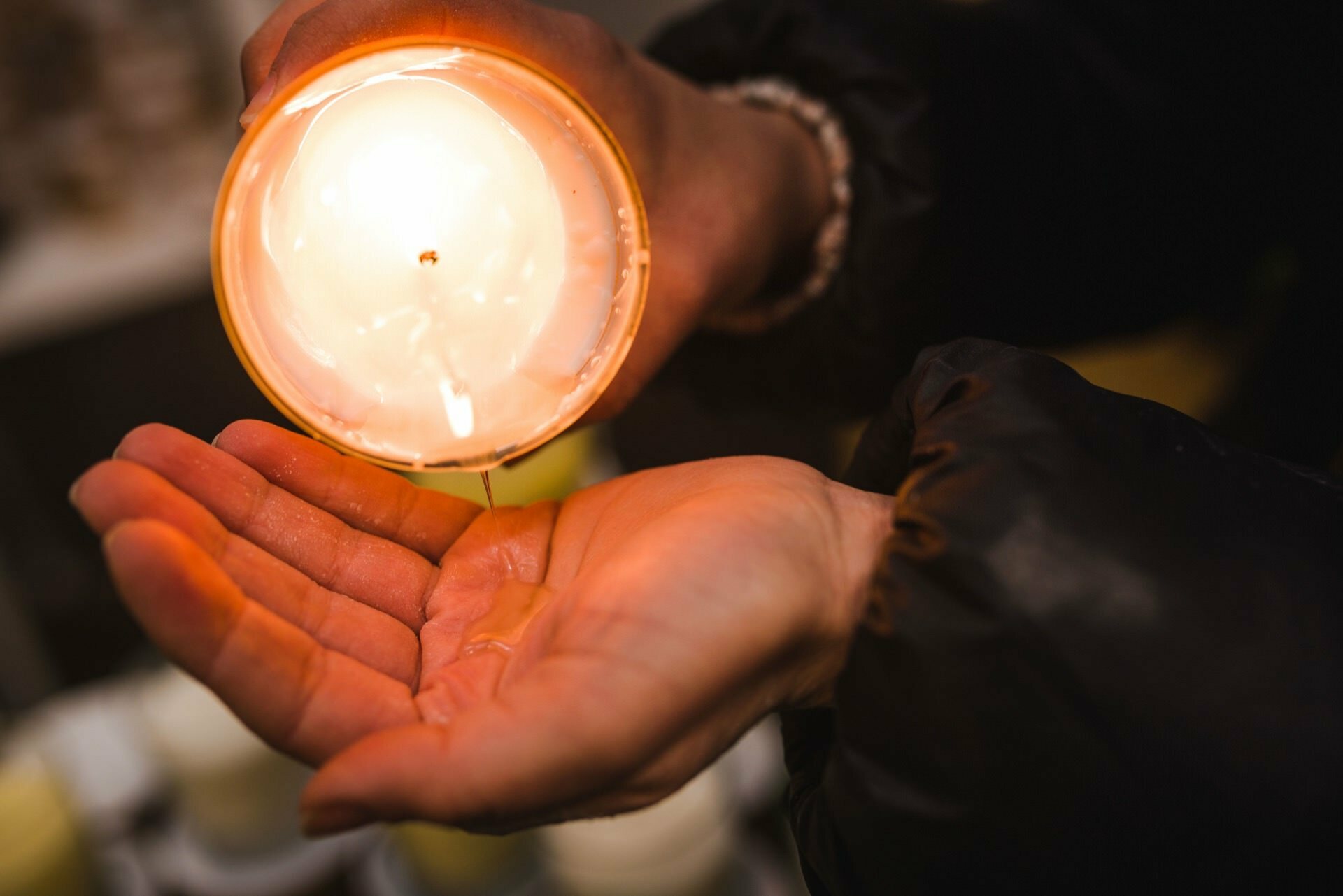 Woman pours heated wax on her palm