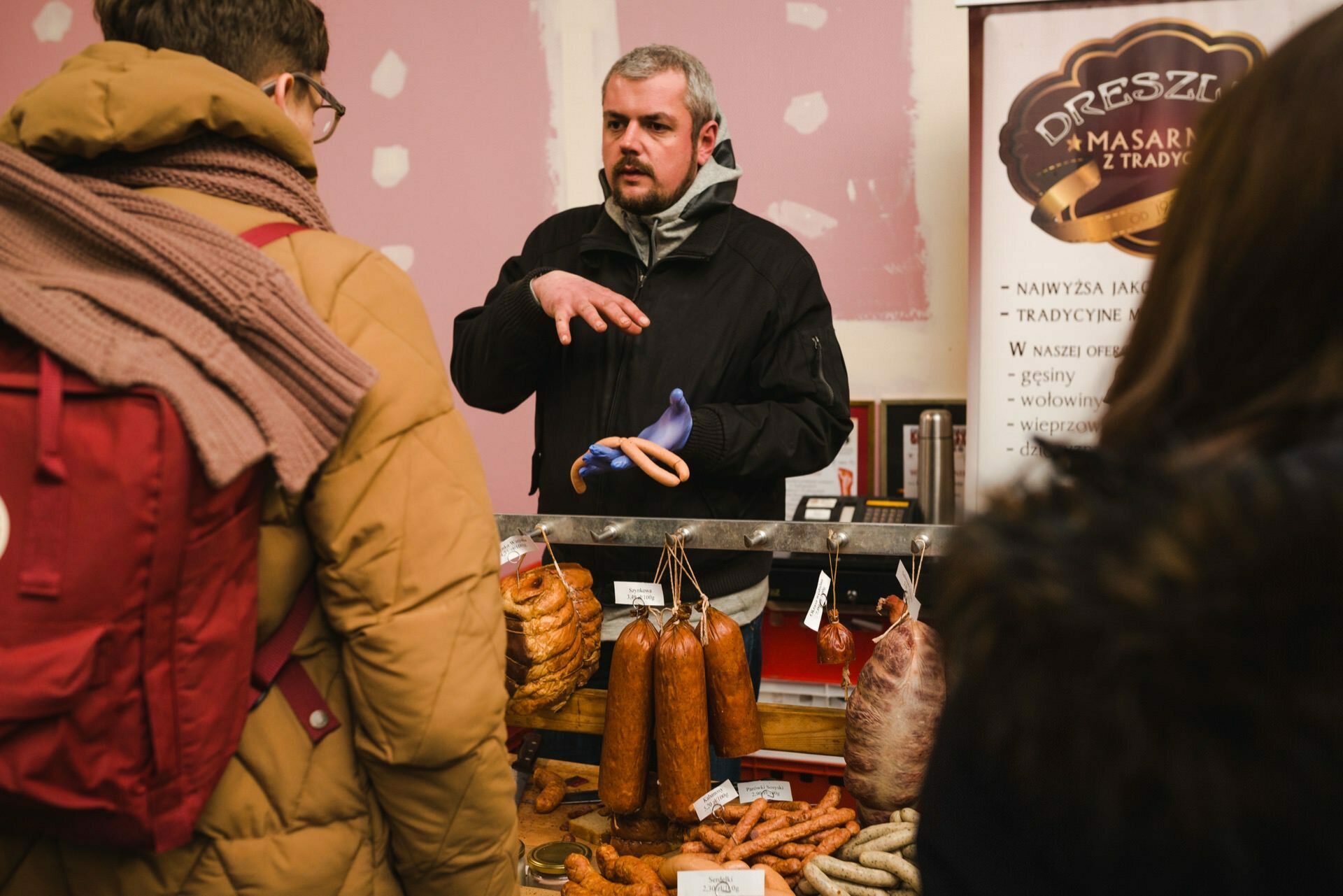 A man at a stand selling butchered products