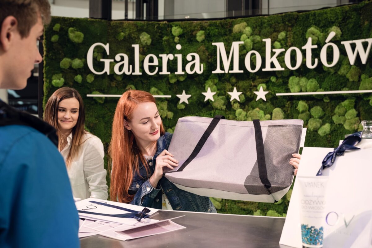 Redheaded girl shows off eco-friendly bag at mall mokota