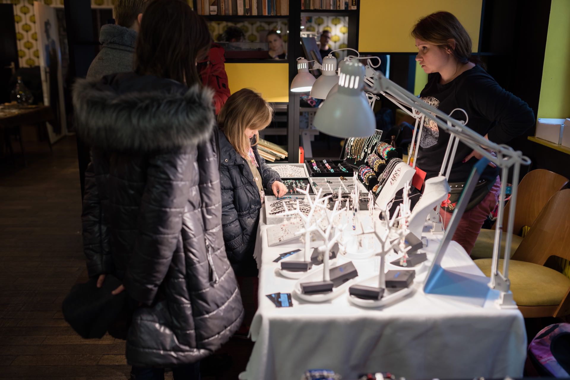 A child looks at jewelry at a fair