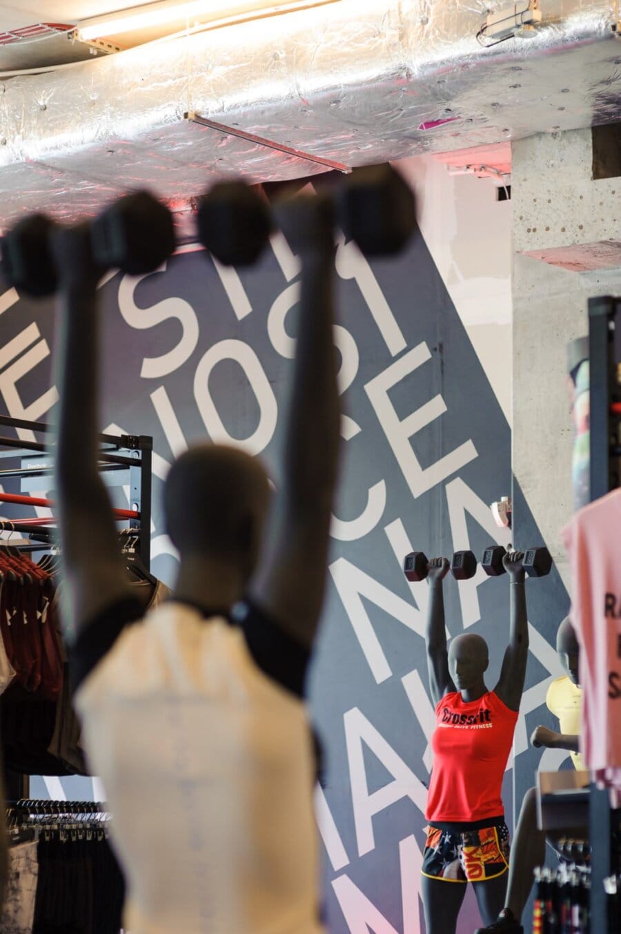 Mannequins holding dumbbells raised high in the air