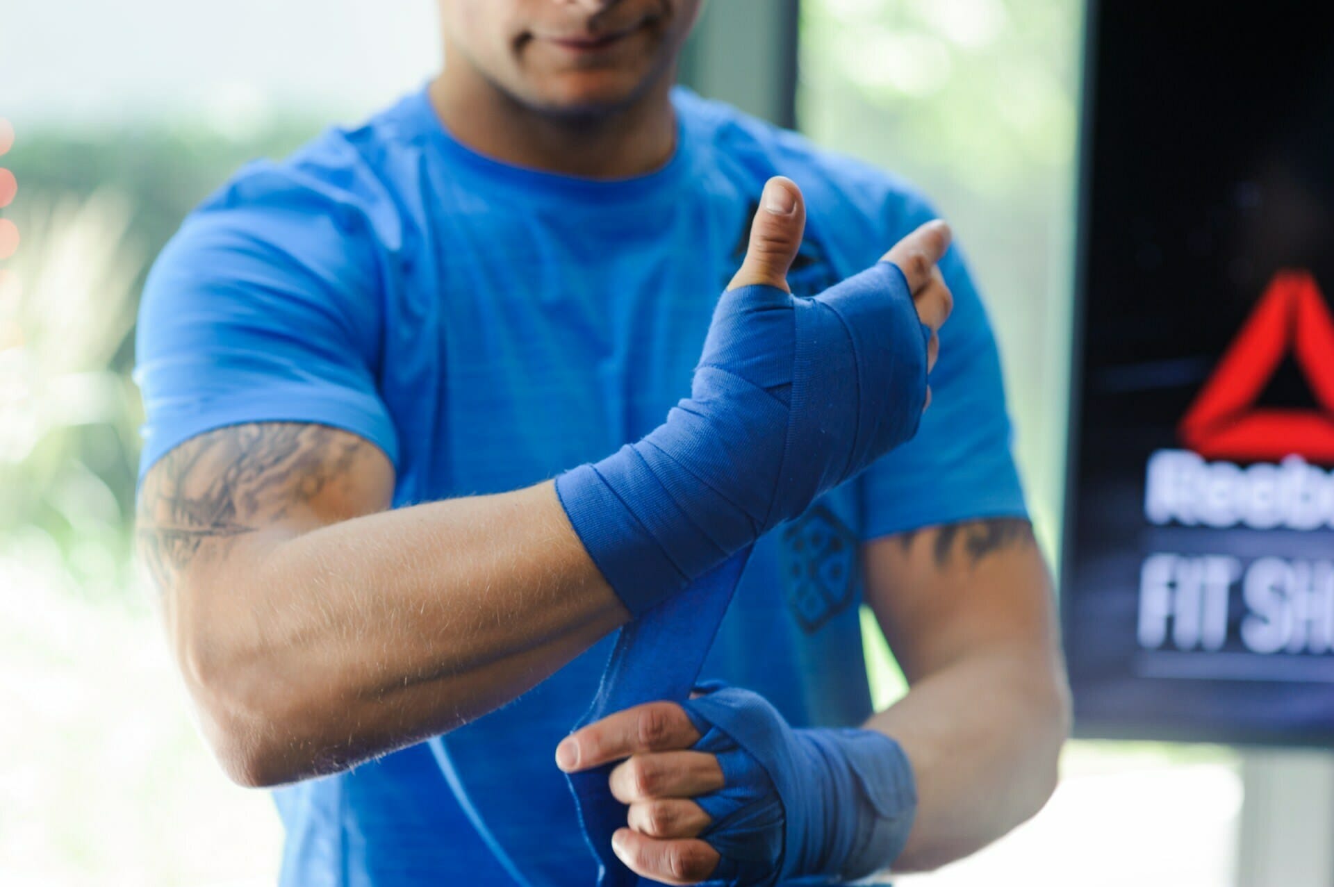 The competitor ties blue ribbons around his hands