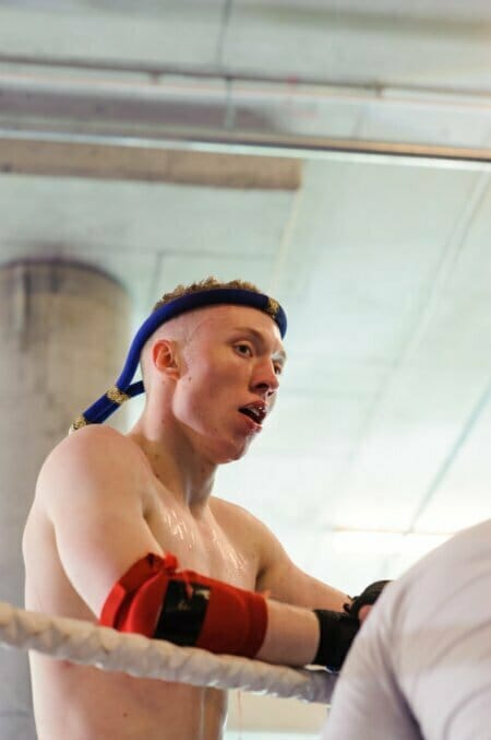 Sweaty fighter leaning against the ring rope