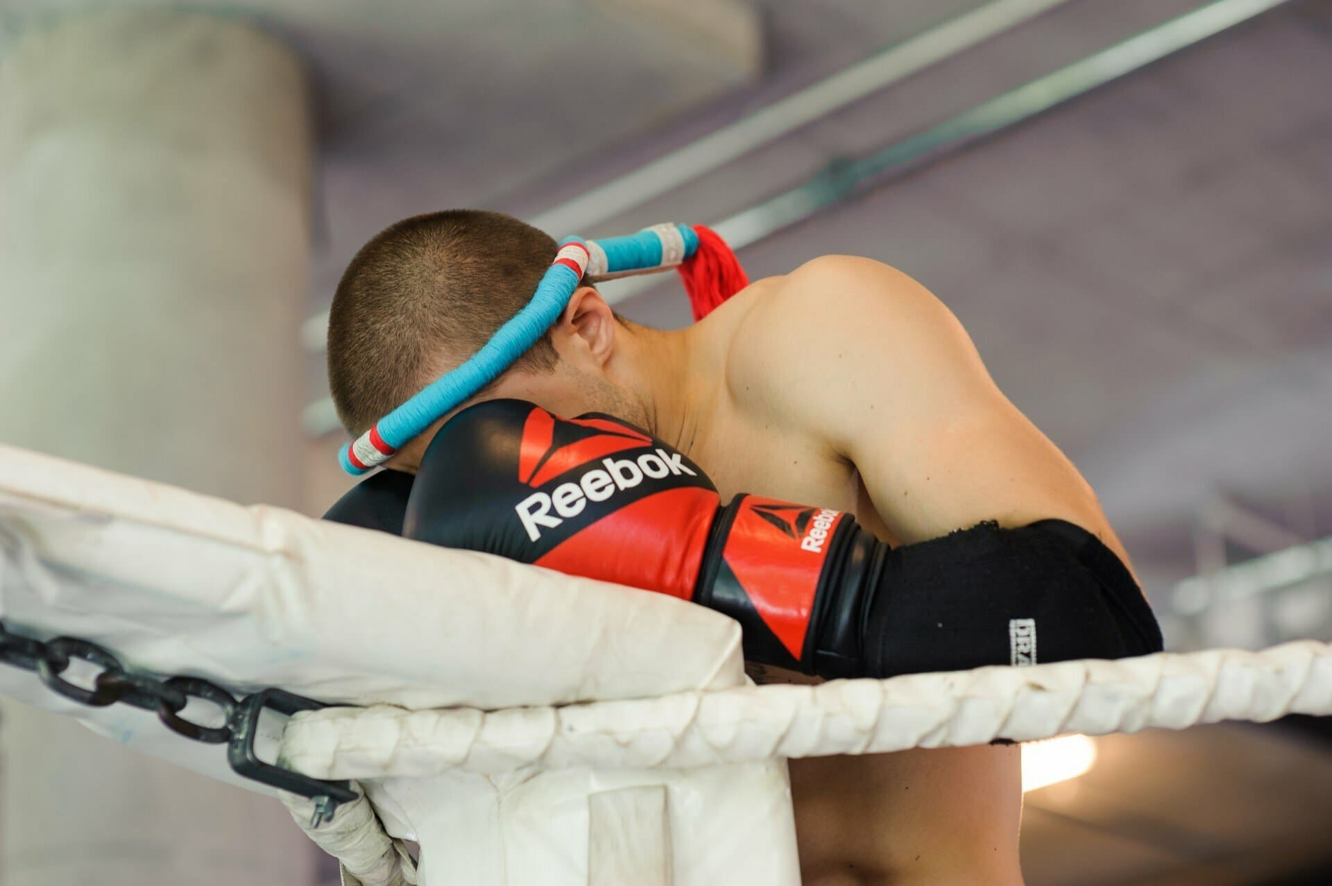 Warrior holds his face in the corner of the ring in his hands