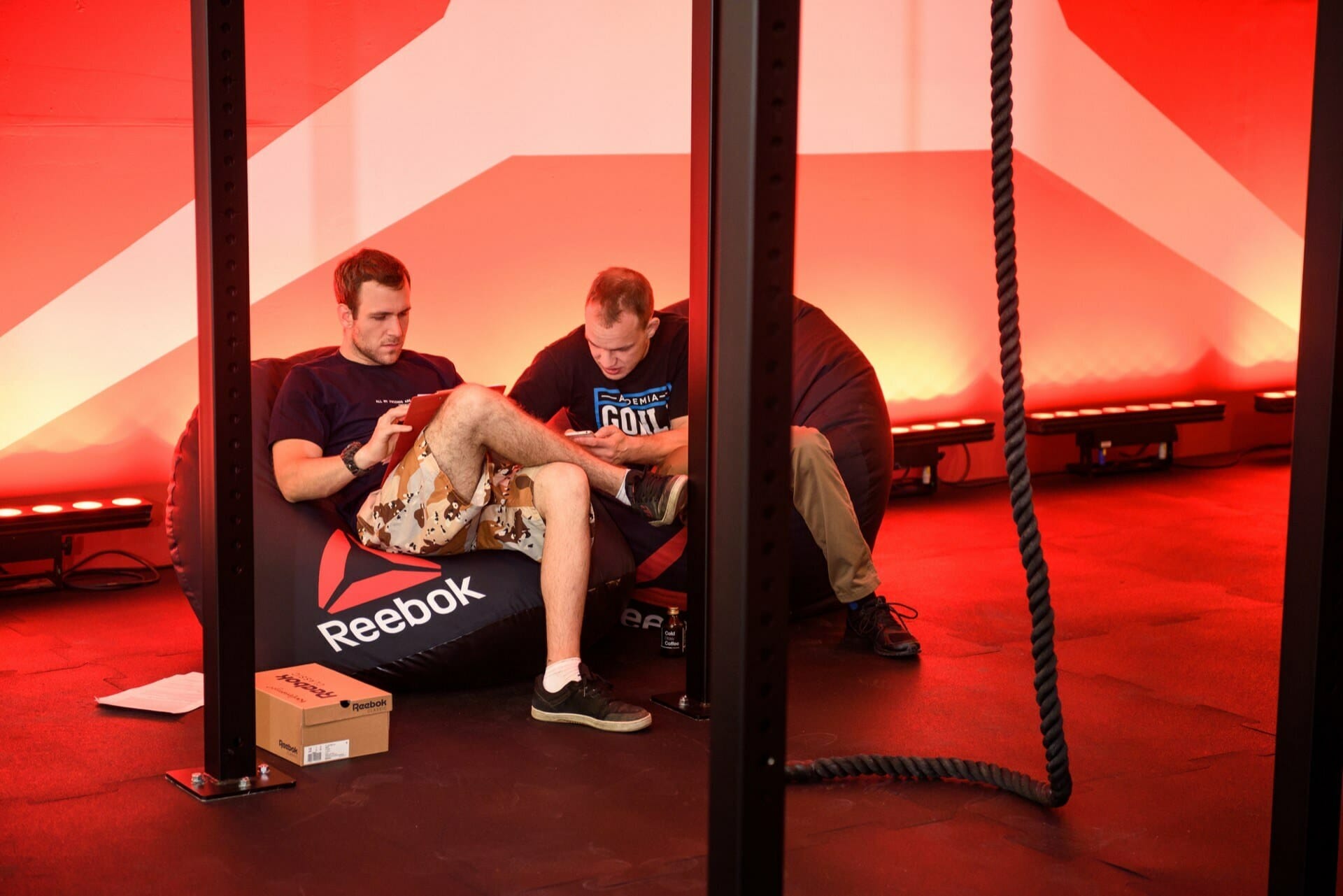 Competitors on black poufs with reebok octagon logo