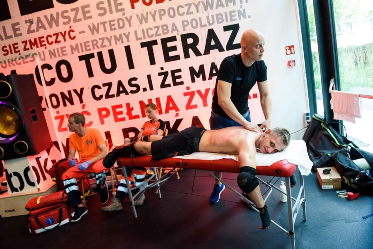 Masażysta masuje zawodnika po walce