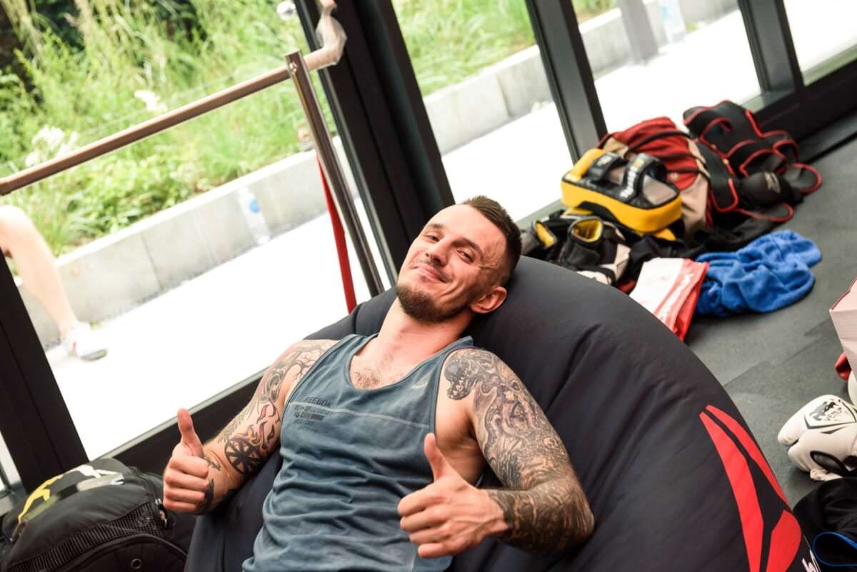 Chłopak z tatuażami na pufie reebok octagon