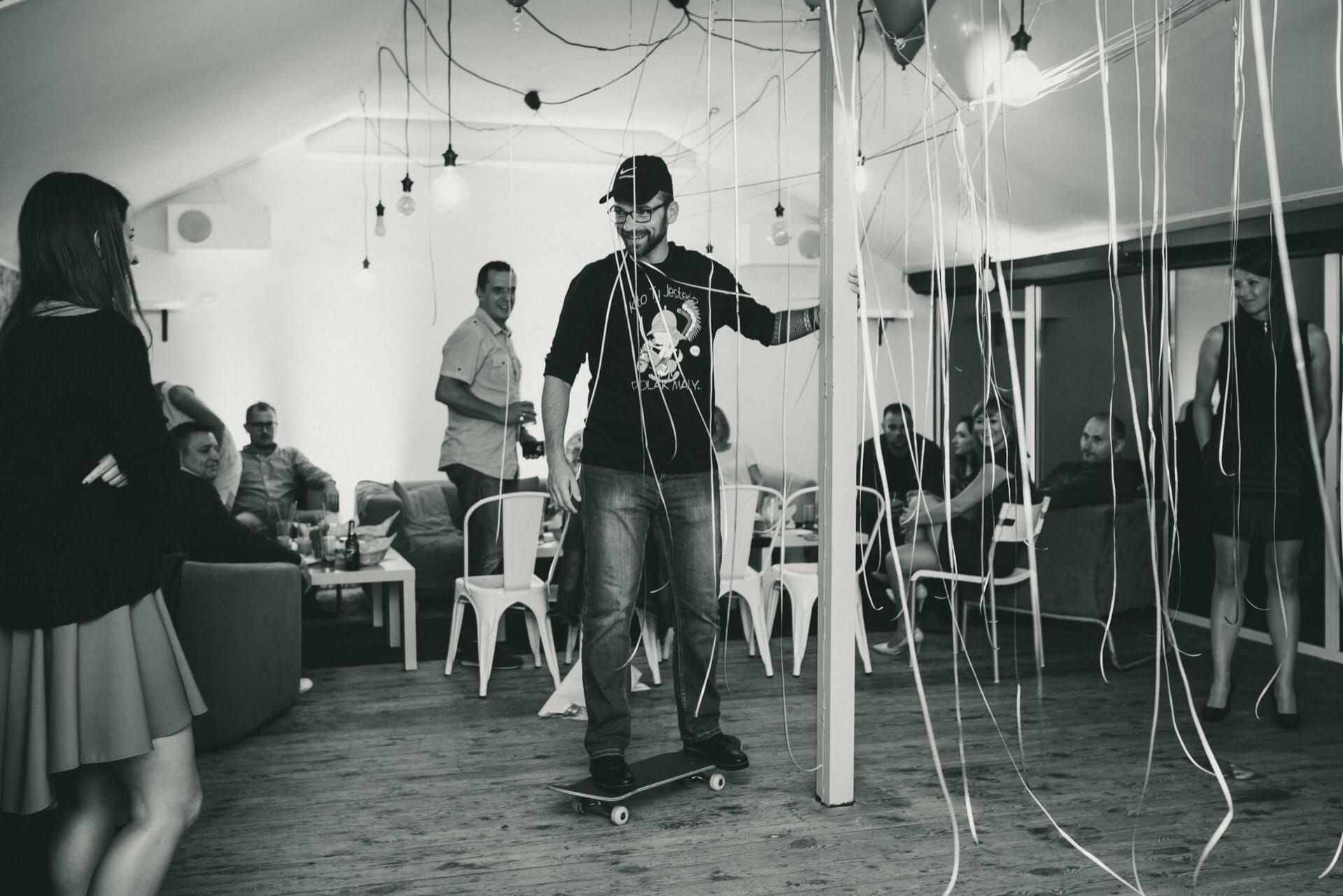 A birthday boy rides a skateboard across the dance floor at a club