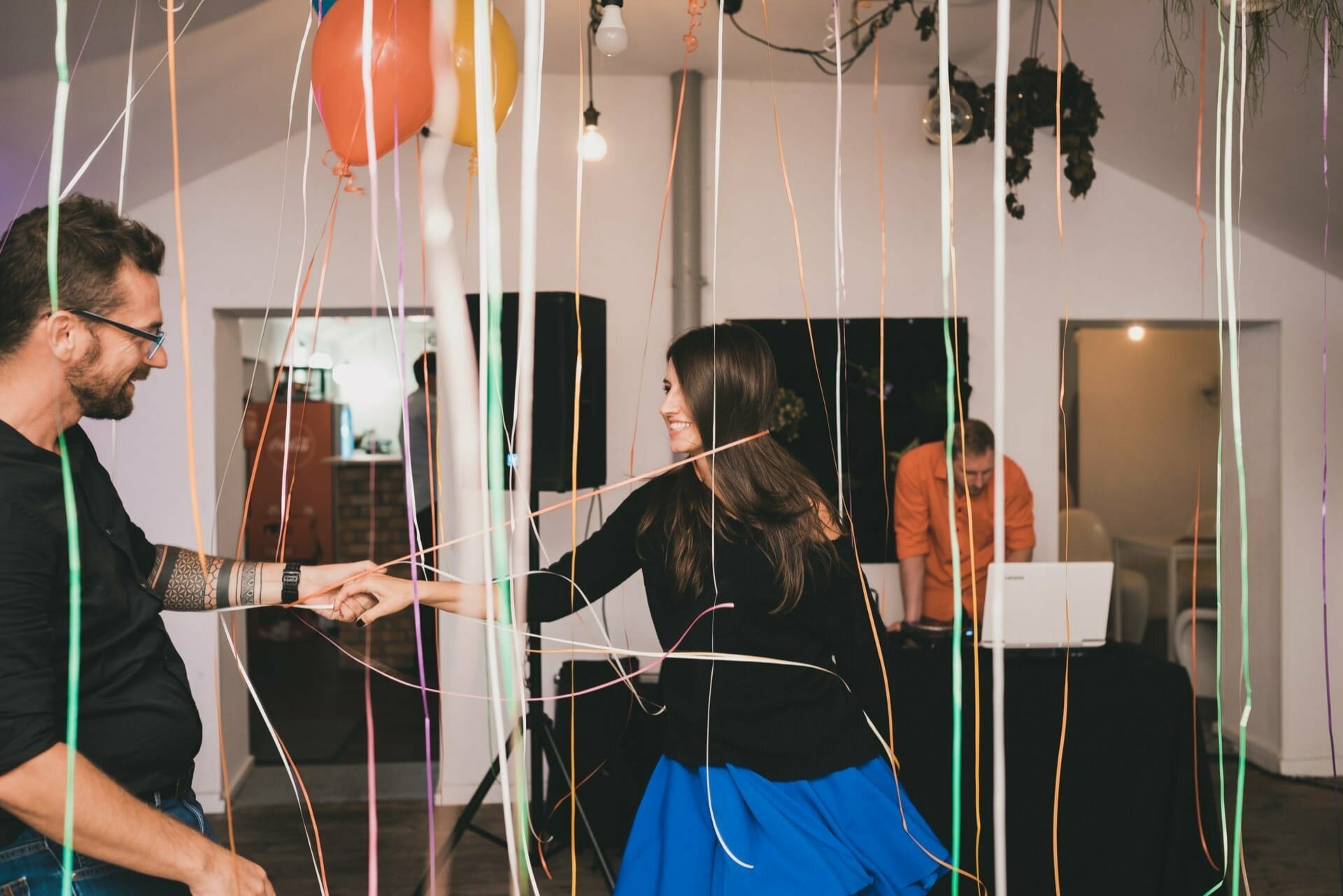 Couple dancing between helium balloons and ribbons