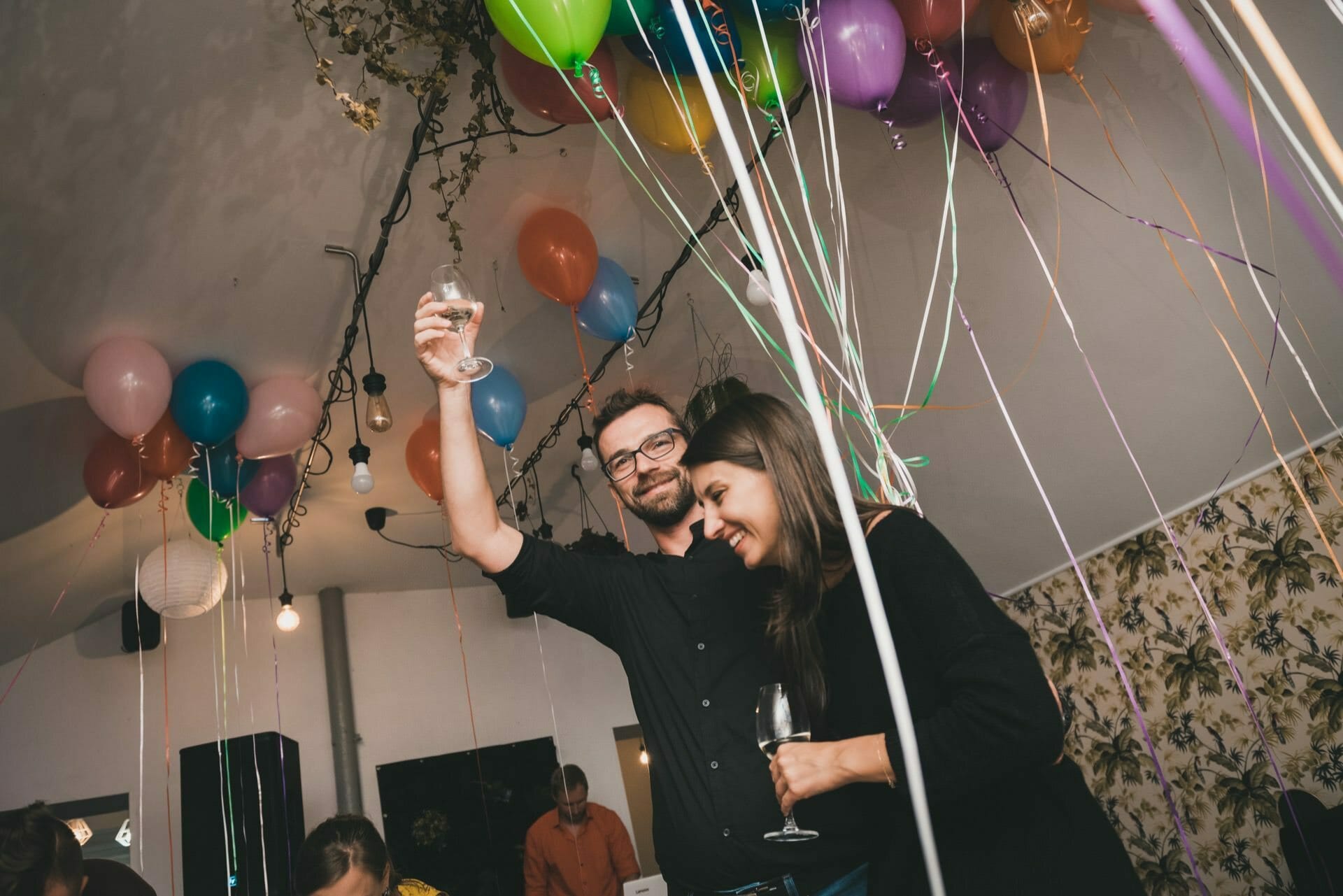 The birthday boy raises his glass of wine in the air