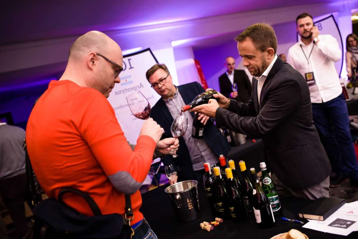 degustacja win przez mężczyznę w czerwonym swetrze