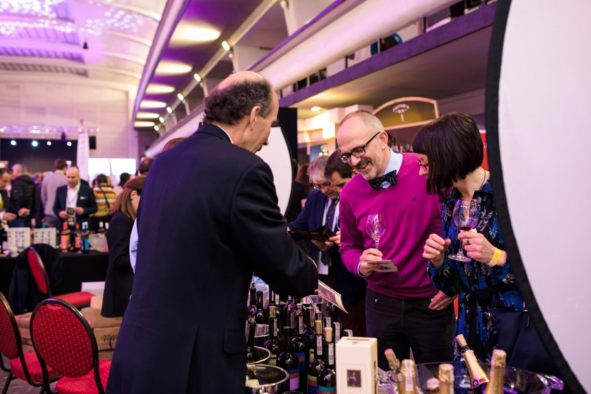 Man in pink sweater holds wine glass