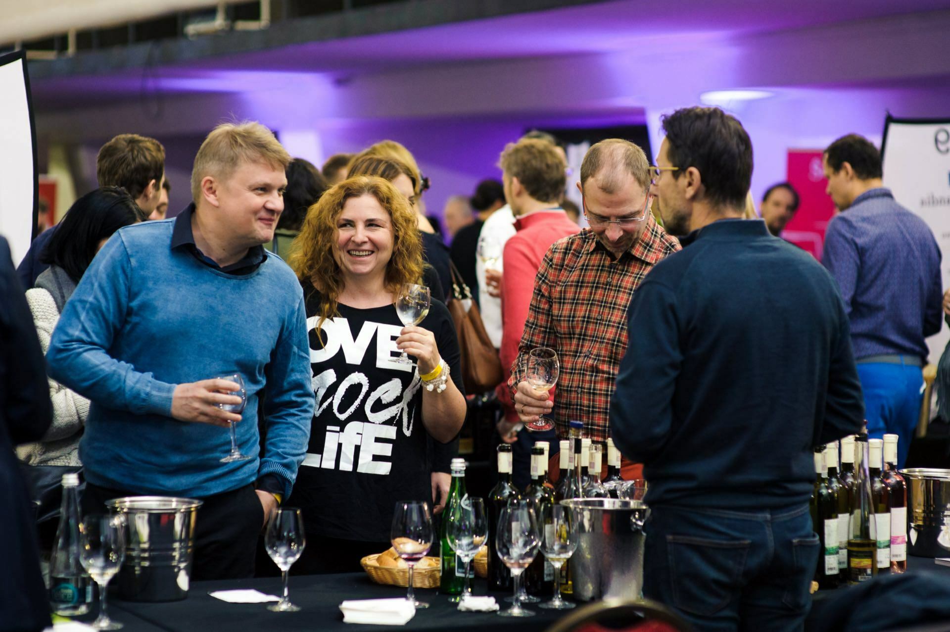 Smiling people with glasses of wine in their hands