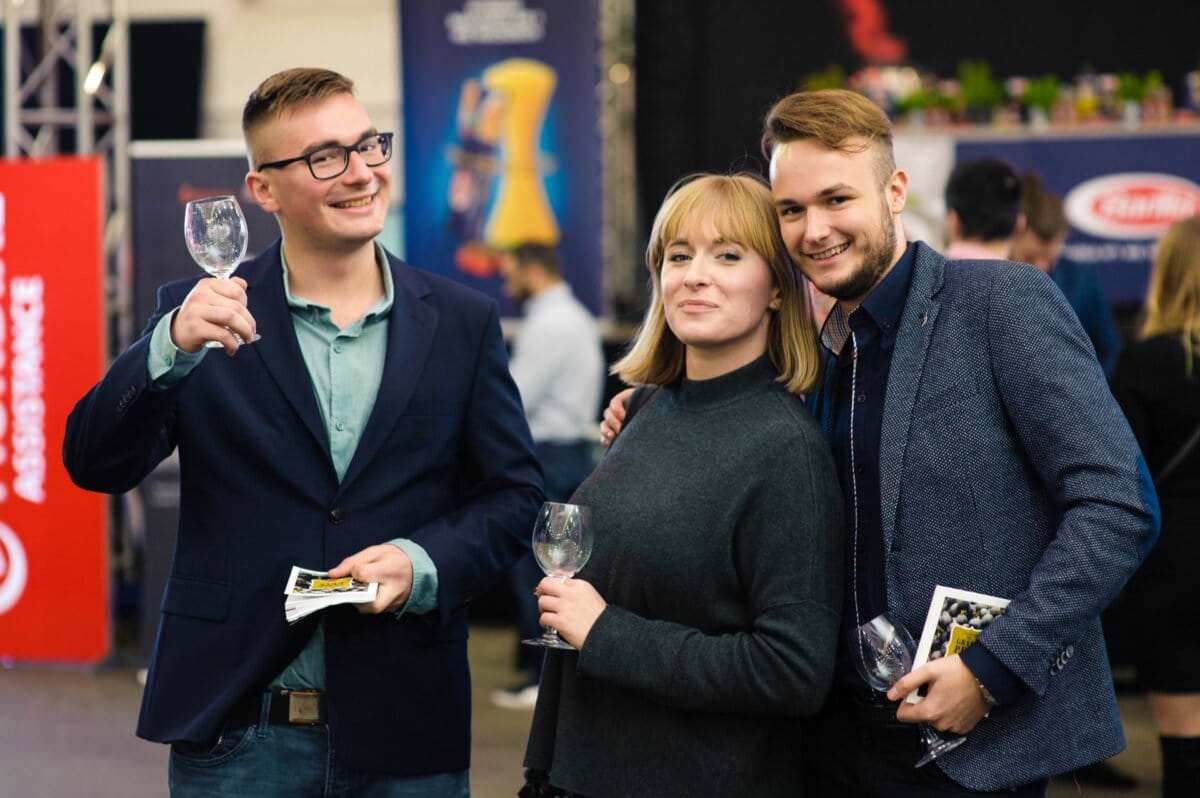 Uśmiechnięci ludzie na targach wina grand prix magazynu wino