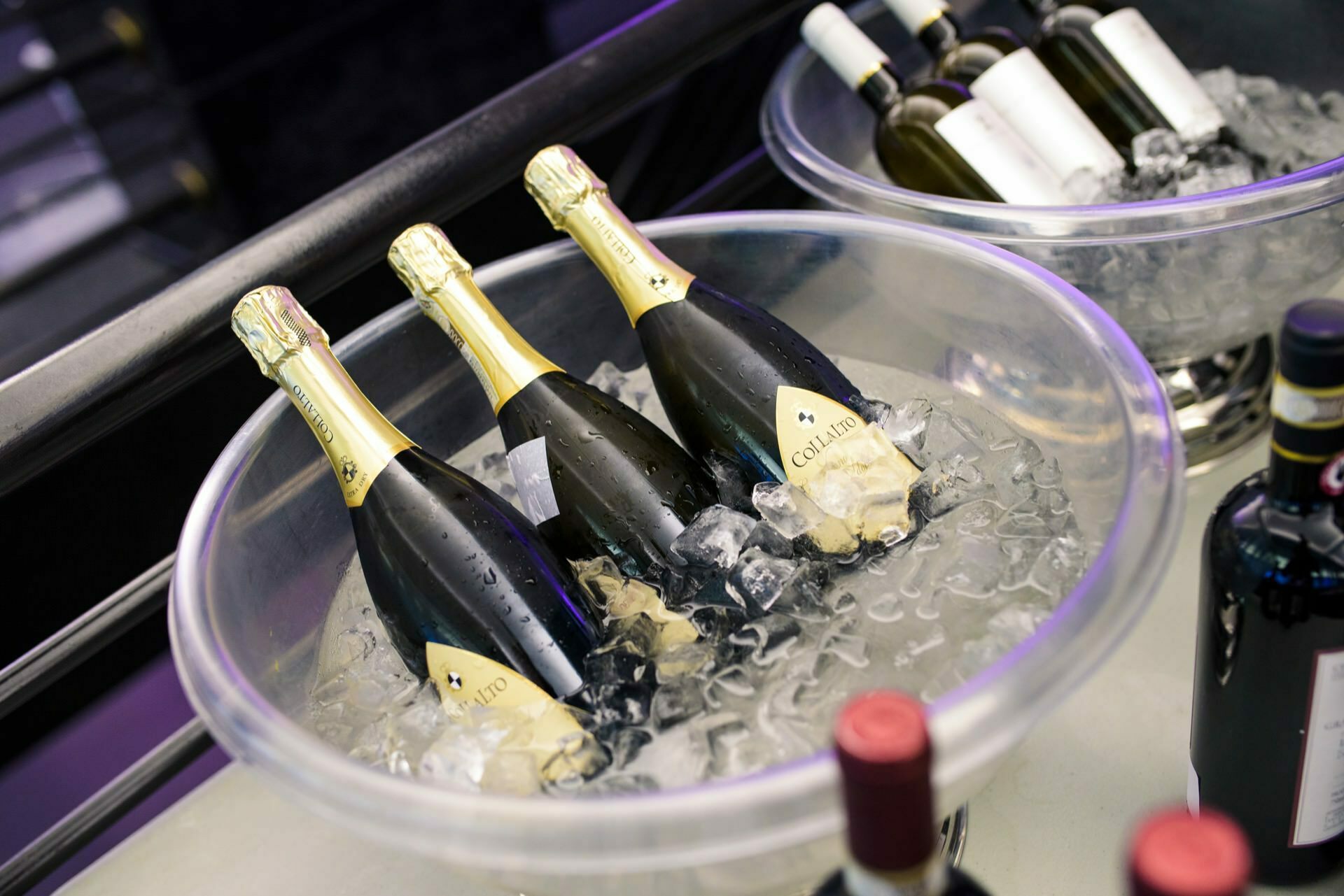 Bottles of wine in a clear bowl with ice