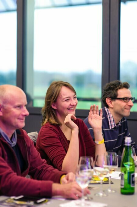 Smiling woman in front of whom are glasses of wine