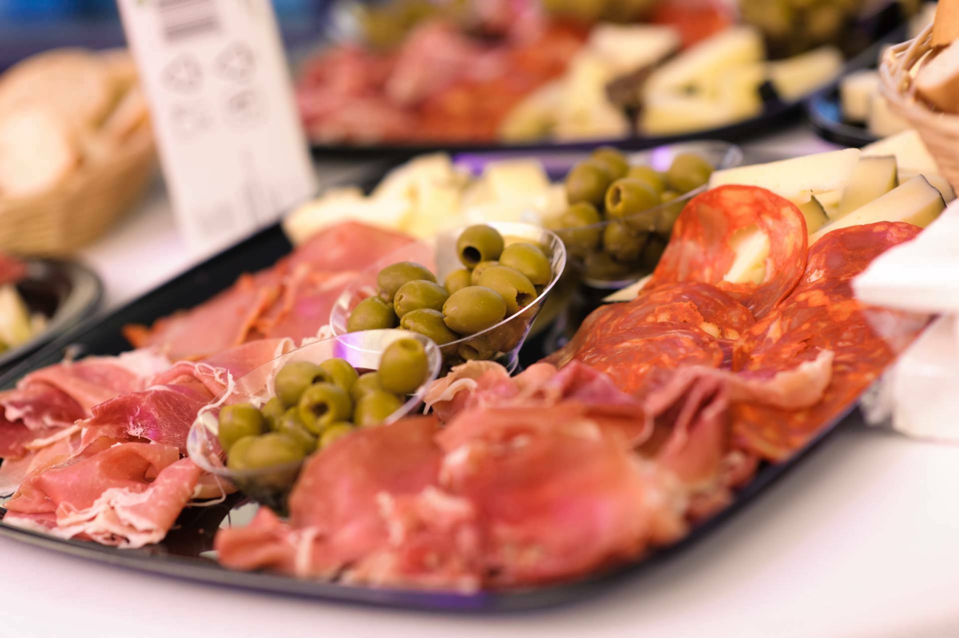 Olives, aged ham and salami on a plate