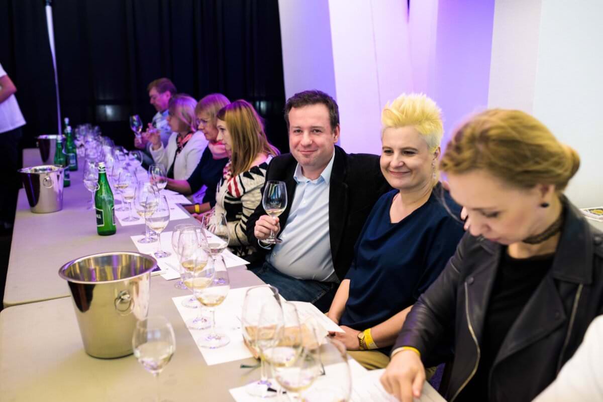 Mężczyzna smakujący wino uśmiecha się do obiektywu