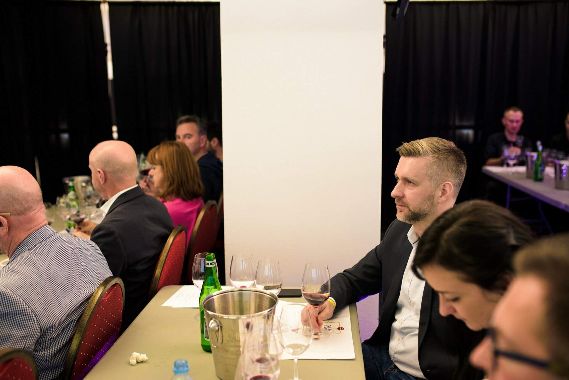 A man tasting wine looks ahead