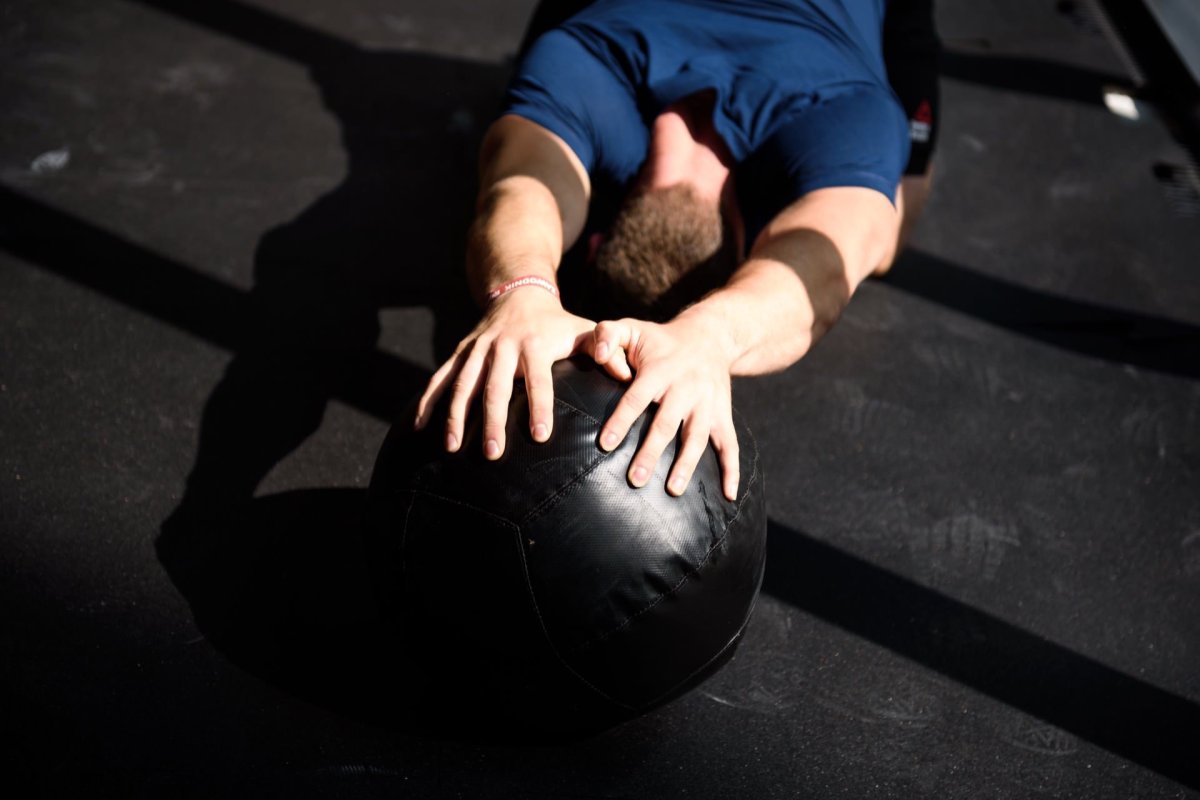 Hands on a medicine ball in harsh sunlight