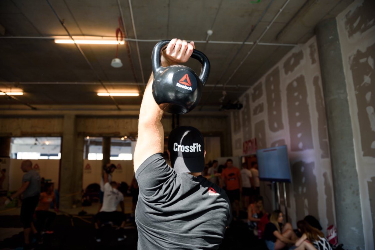 Kettlebell over the head of a boy wearing a CrossFit cap