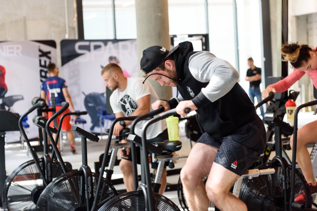 Boy in sweatshirt and cap on exercise bike