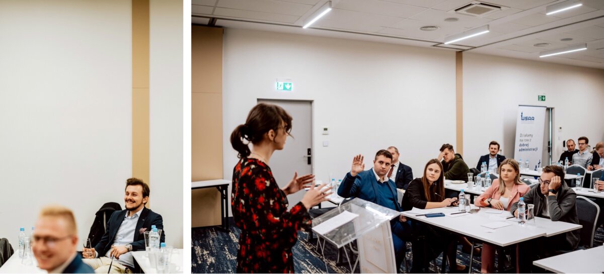 Kobieta w czerwono-czarnej sukience w kwiaty przemawia na czystym podium w sali konferencyjnej. Słucha kilku siedzących osób, a jedna podnosi rękę. Na stołach leżą papiery i butelki z wodą, a sala jest nowocześnie oświetlona, co uchwyciła fotorelacja z wydarzeń autorstwa Marcina Krokowskiego.