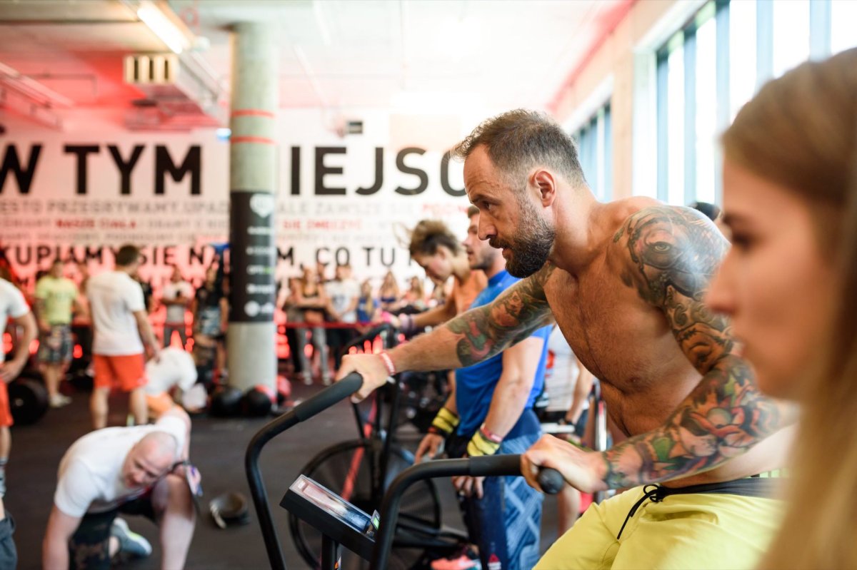 Man with tattoos on exercise bike during competition