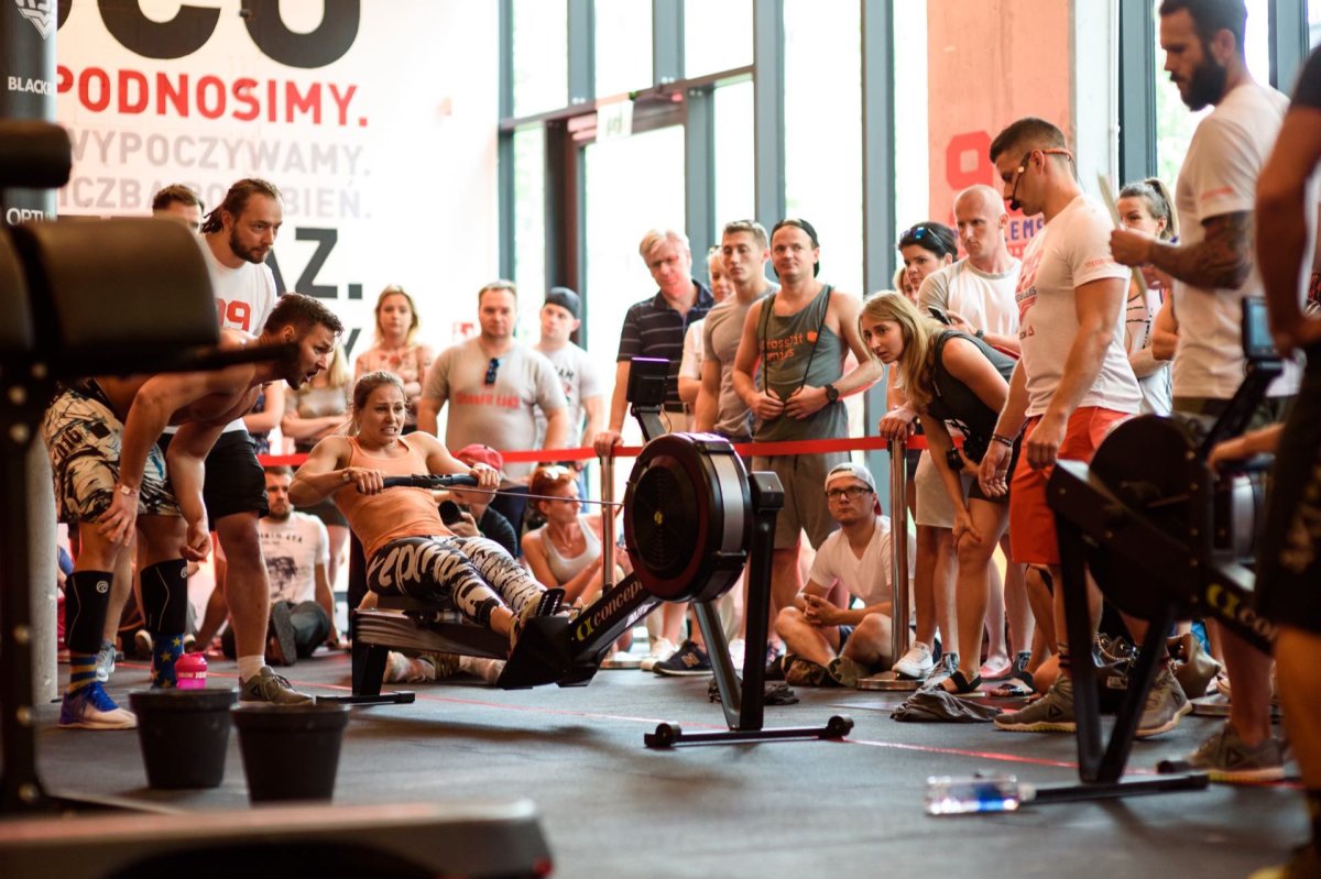 Girl rowing on machine during crossfit competition