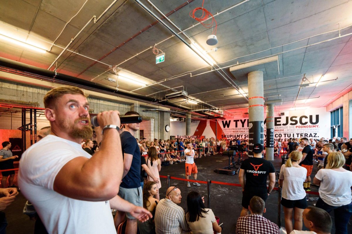 White-shirted judge speaks into microphone at crossfit competition