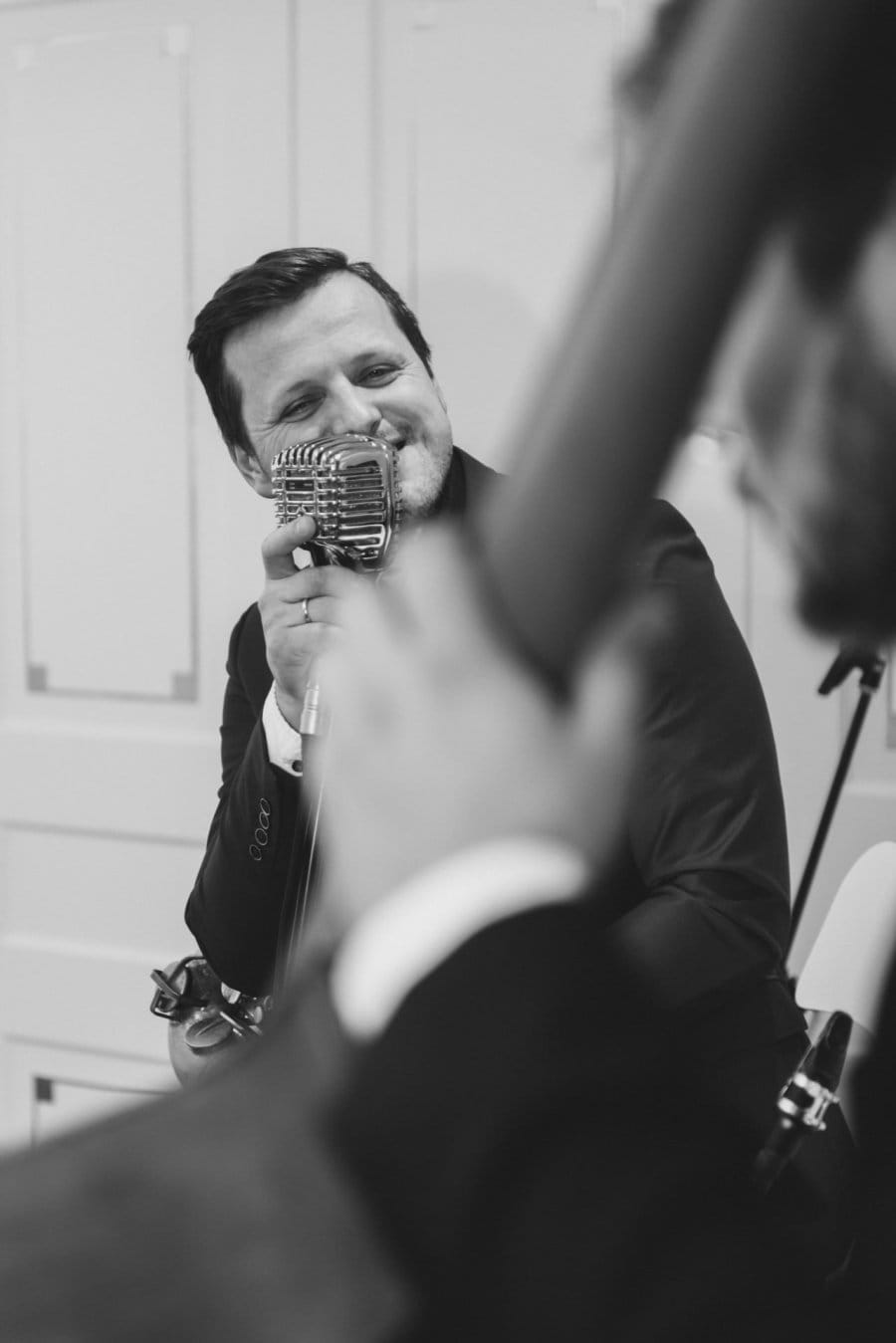 A man singing into a classical microphone