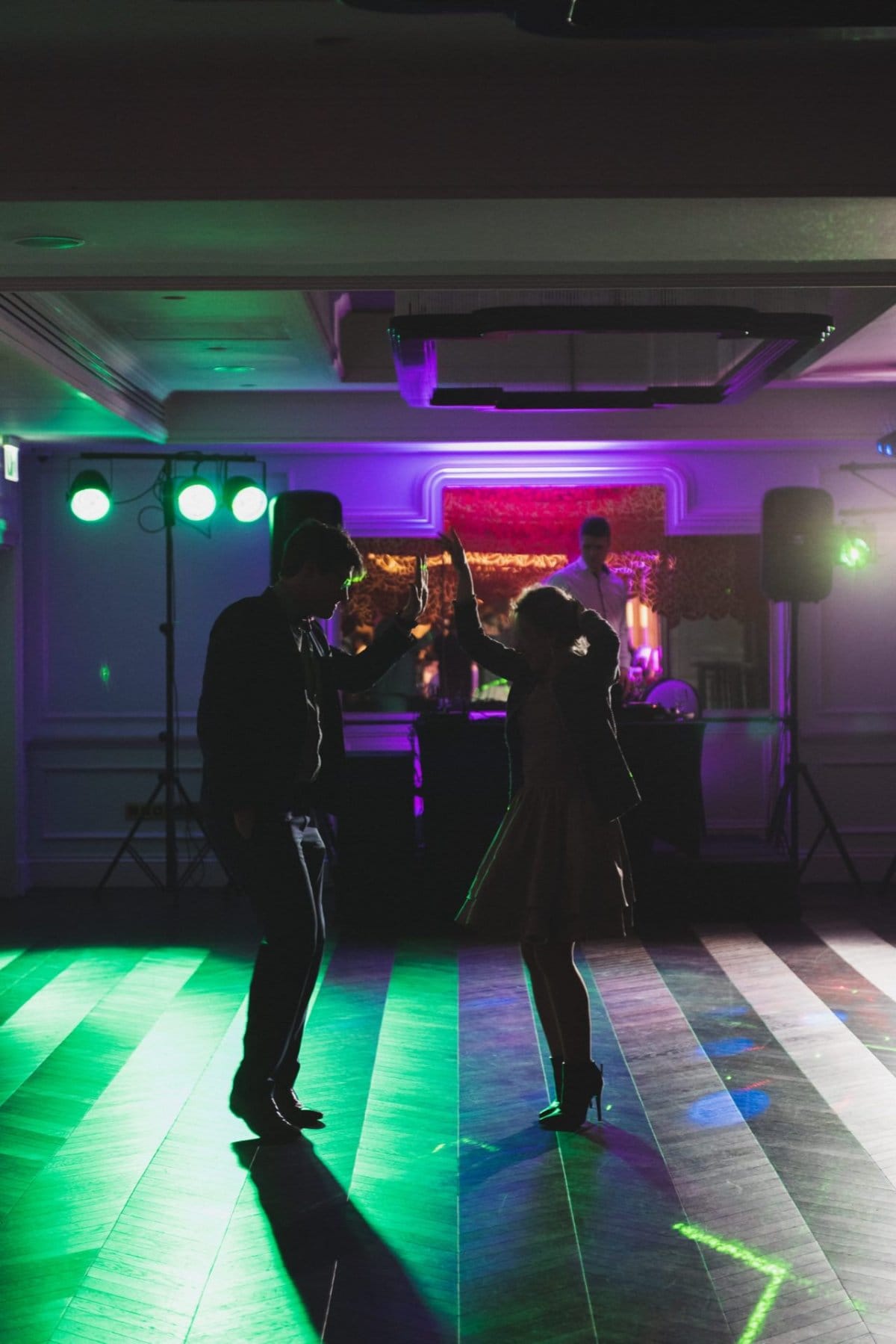 Couple dancing in the light of DJ's lamps