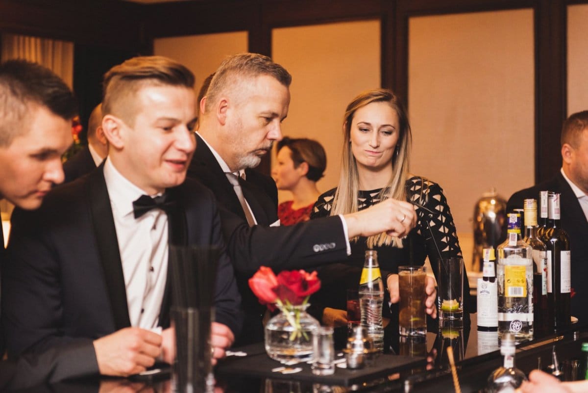 Woman looks at the drink the man standing at the bar ordered