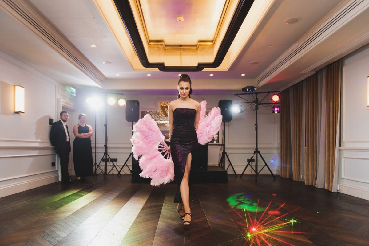 Woman with pink plumes walks in long dress