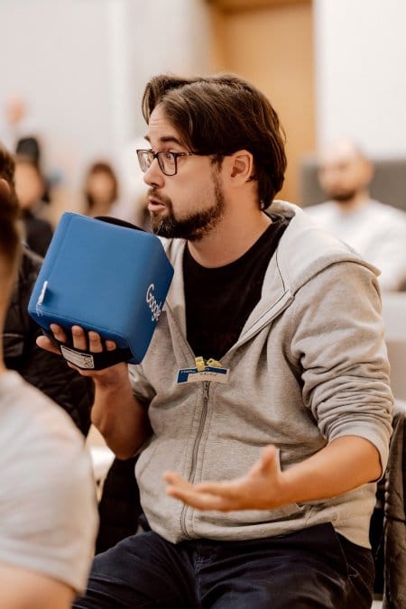 A conference attendee speaks into a microphone with Google written on it