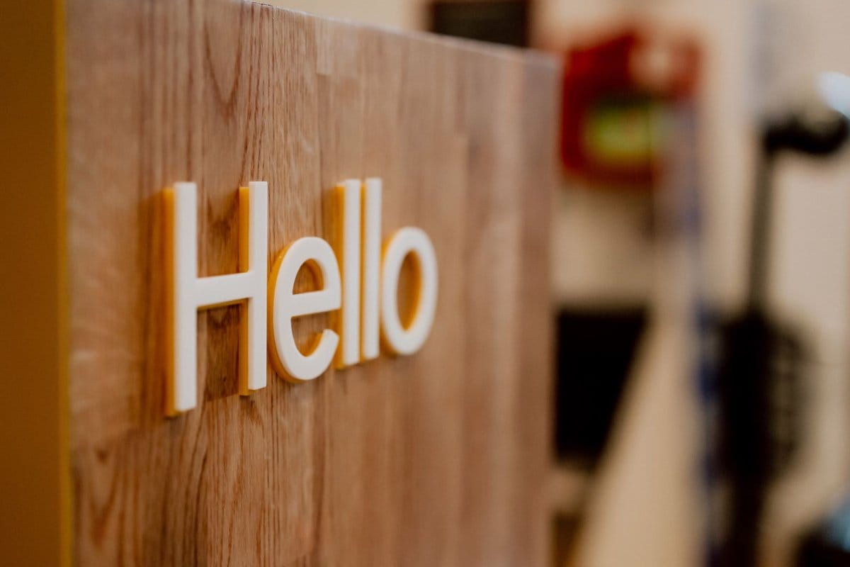 White Hello sign on a wooden platform