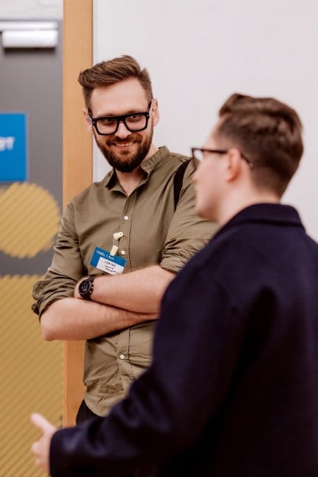 Boy in thick frames talks to another boy in glasses