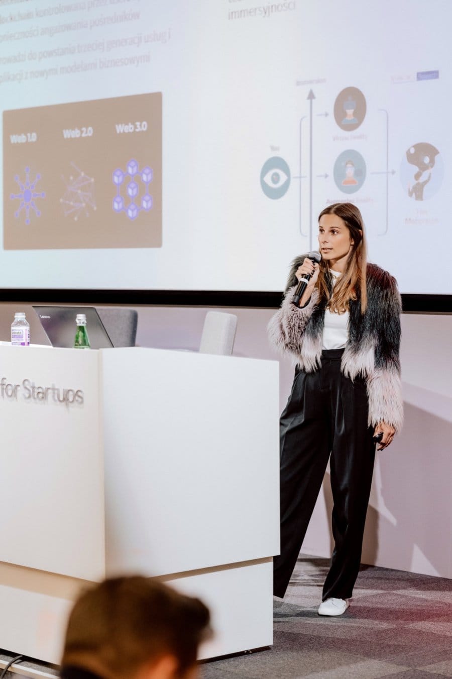 Woman speaks into microphone at conference