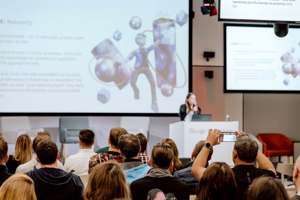 Man n audience takes photo of presentation at conference