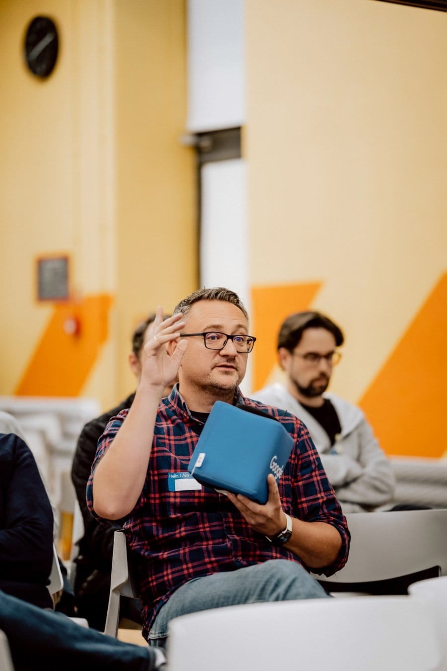 Conference participant wants to ask a question while sitting with a blue microphone