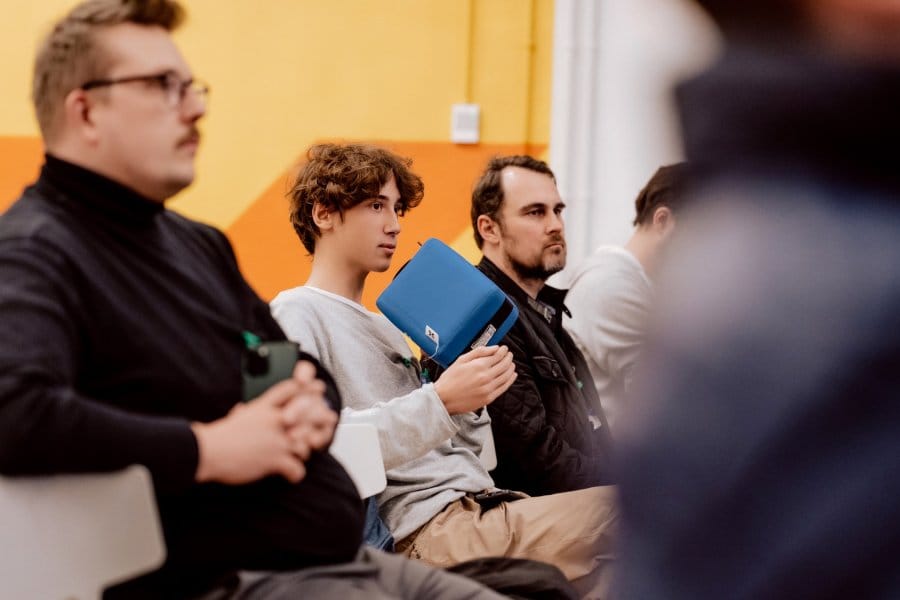 A boy in the audience speaks into a blue microphone