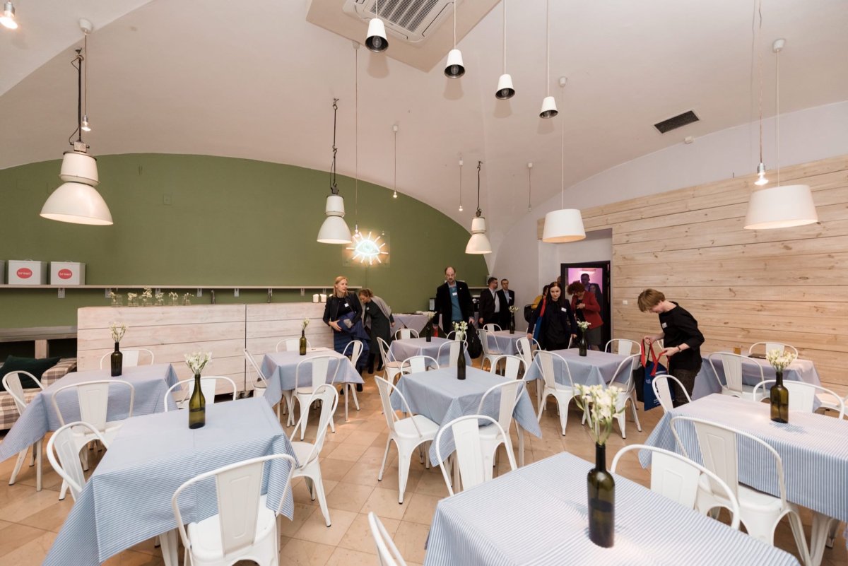 People entering a room full of tables and chairs